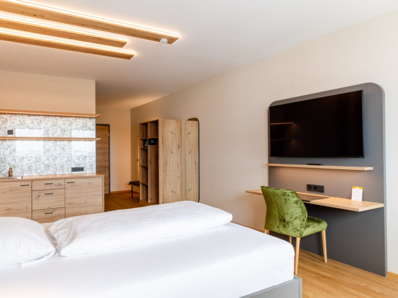 Einrichtung Apartment mit Bett, Küchennische, Kleiderschrank und Smart-TV